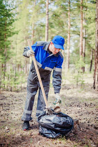 Side view of man working in forest