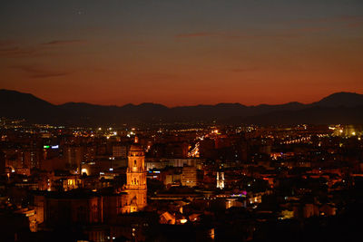 High angle view of illuminated city against sky at night