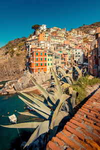 Aerial view of buildings by canal against clear blue sky