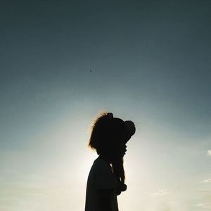 Low angle view of boy wearing lion headwear against sky