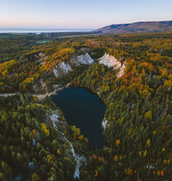 High angle view of lake amidst landscape against sky during autumn