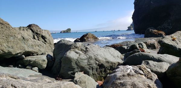 Rocks on beach against clear sky