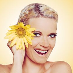 Portrait of smiling woman holding yellow flower