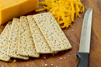 Close-up of crackers with cheese on cutting board