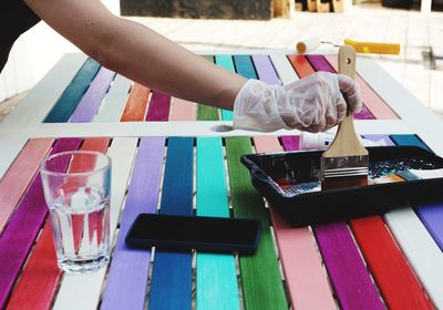 Close-up of hand holding glasses on table