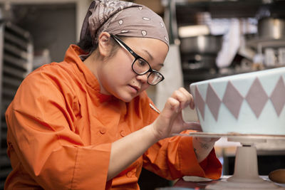 Woman decorating cake at store