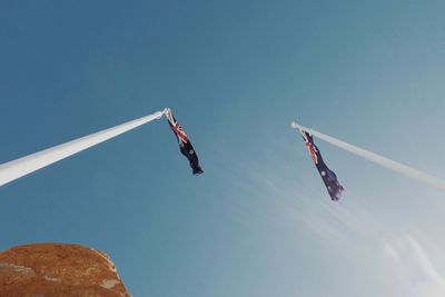 Low angle view of flags against clear sky