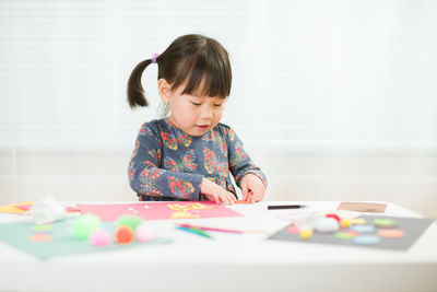 Portrait of cute girl playing on table