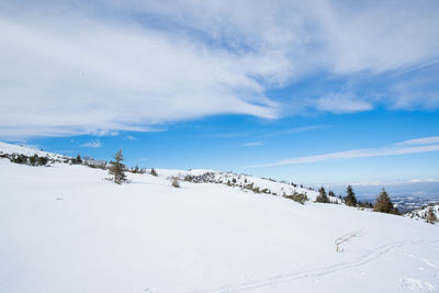 Snow covered landscape against sky