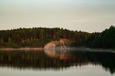 Scenic view of lake in forest against sky