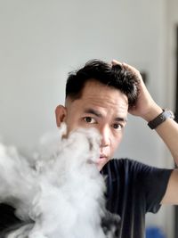 Portrait of smiling young man looking at the camera with smoke