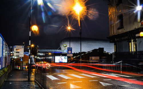 Light trails on street amidst buildings in city at night