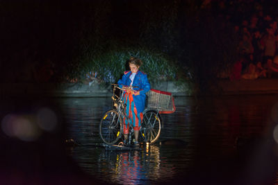 Man riding bicycle on riverbank