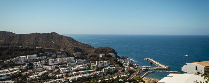 High angle view of buildings by sea against clear sky