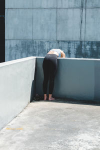 Rear view of woman standing by swimming pool