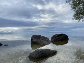 Rocks in sea against sky