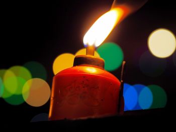 Close-up of lit candle in dark room