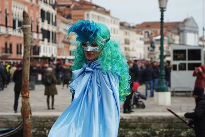 Midsection of woman with umbrella mask in city