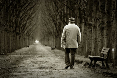 Rear view of woman walking on road