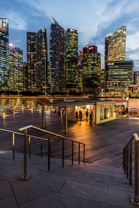 Illuminated modern buildings in city against sky