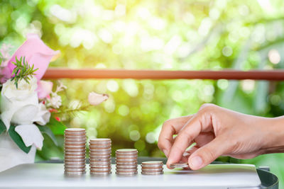 Close-up of hand holding coins on table