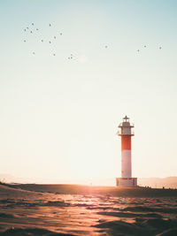 Low angle view of lighthouse against sky during sunset