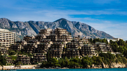 Built structures against the sky with river in foreground