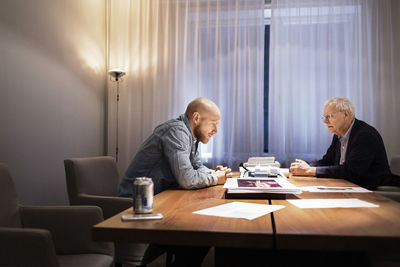 Side view of businessmen sitting at conference table