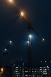 Low angle view of illuminated lights against sky at night