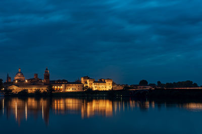 Reflection of illuminated buildings in lake at dusk