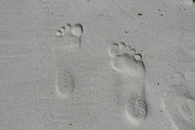 Close-up of footprints on sand at beach