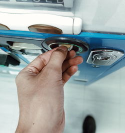 Cropped hand inserting coin in machinery