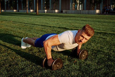 Low section of man exercising on field