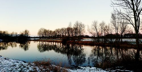 Scenic view of lake against clear sky during sunset