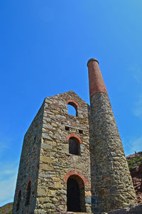 Low angle view of old building against blue sky