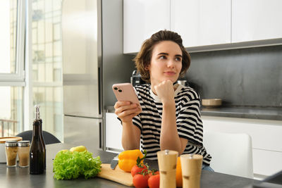 Portrait of young woman drinking coffee at home