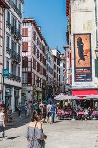 People on street against buildings in city