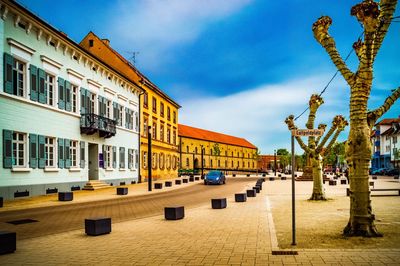 Buildings by street in town against sky