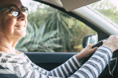 Midsection of man using mobile phone while sitting in car