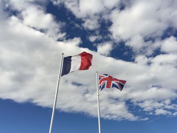 Low angle view of flag flags against sky