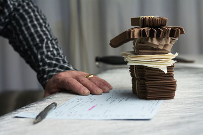 Close-up of shoemaker with documents and samples in his workshop