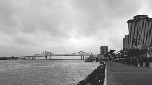 Bridge over river against cloudy sky