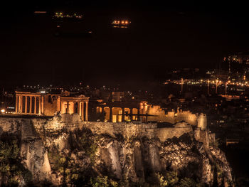 Illuminated cityscape against sky at night