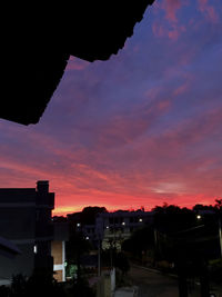 High angle view of silhouette buildings against sky during sunset