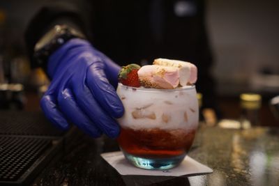 Close-up of hand holding ice cream on table