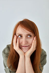 Portrait of smiling young woman against gray background