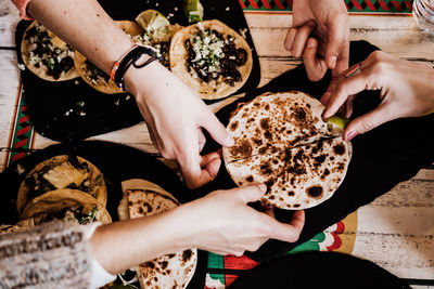 High angle view of people holding food on table