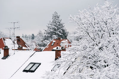 Houses on snow field against clear sky