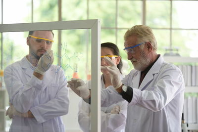 Scientist discussing formula while standing in laboratory
