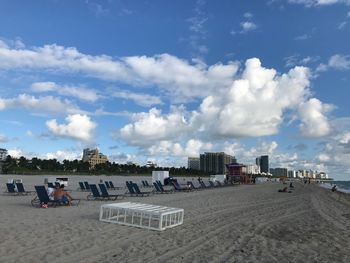 Group of people on beach against sky